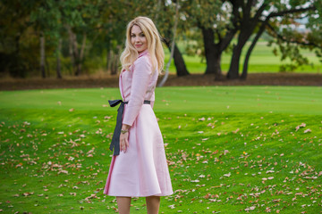 Fashionable concept. Romantic lady in pink trench outdoors 