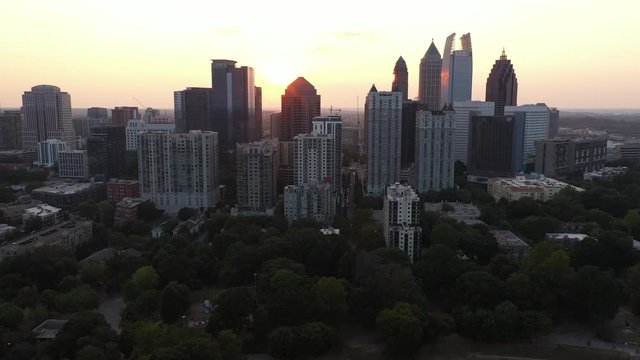 4K Ariel Drone Shot Across Skyline Buildings In Charlotte, North Carolina, USA. Sun Shining Through Gaps Of Buildings. Skyline Tall Buildings. Busy Road Cars Passing Through. Sun Shining