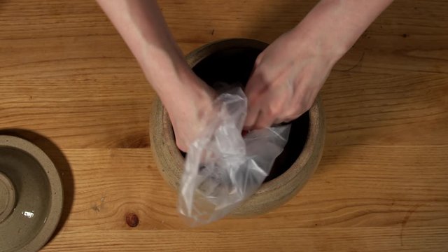 a Japanese female chef salting Nanko-Ume plums at her home kitchen, Tokyo, Japan. July 2019. Camera fixed, close-up, bird's eye view