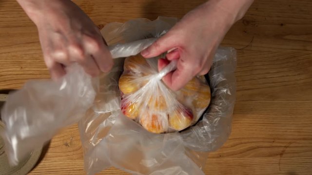 a Japanese female chef salting Nanko-Ume plums at her home kitchen, Tokyo, Japan. July 2019. Camera fixed, close-up, bird's eye view