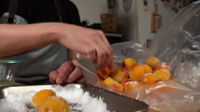 a Japanese female chef salting Nanko-Ume plums at her home kitchen, Tokyo, Japan. July 2019. Camera fixed, close-up, neutral view