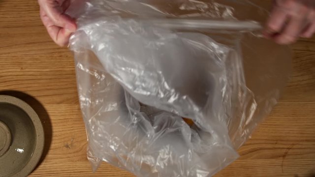a Japanese female chef salting Nanko-Ume plums at her home kitchen, Tokyo, Japan. July 2019. Camera fixed, close-up, bird's eye view