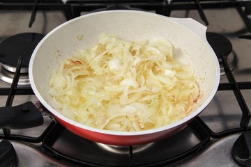 Fried onions in oil in a frying pan