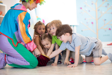 Clown entertaining preschool kids on birthday party. Games with animator