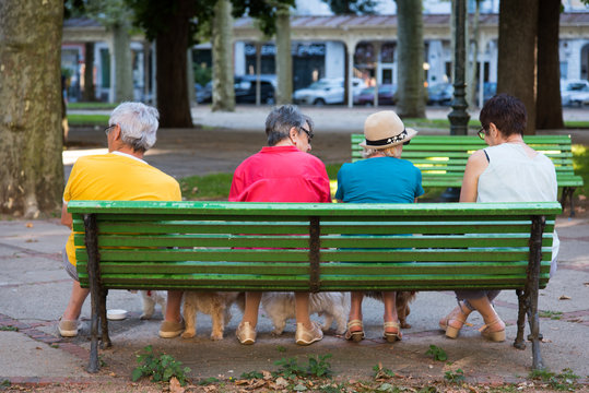 des personnes &acirc;g&eacute;es assises sur un banc parlent