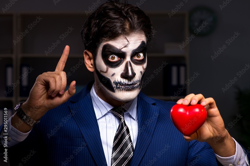 Wall mural businessman with scary face mask working late in office