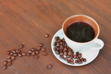 Hot Coffee cup and roasted Robusta coffee beans  on the wooden table with wooden texture background with copy space,Flat lay.