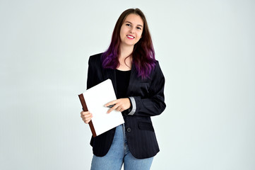 Studio portrait of a pretty brunette student girl with long hair in a jacket on a white background. Smiling at camera with emotions in various poses.