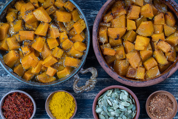 Baked yellow pumpkin with honey, anise, olive oil and spices on a plate on the wooden table. Vegetarian food. Closeup