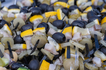 Obraz premium Set of delicious canapes , closeup. Many canapes with black olives, cucumber, lemon, fat and meat on a plate