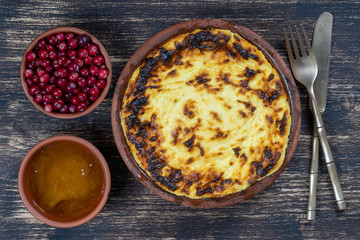 Sweet cottage cheese casserole with raisins and semolina on wooden table. Ceramic bowl with baked cottage cheese casserole , closeup, top view