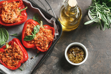 Tasty stuffed pepper with sauce on grunge background