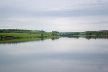 View of the opposite shore of the lake at dusk. Beautiful, serene summer weather. Time after sunset. Copy space.