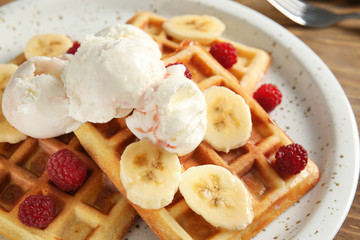 Obraz na płótnie Canvas Tasty waffles with banana and ice-cream on plate, closeup