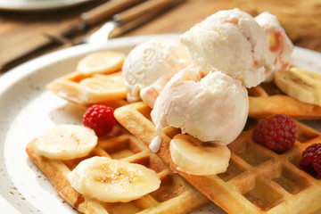 Tasty waffles with banana and ice-cream on plate, closeup