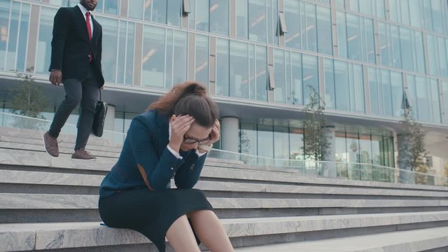 Black handsome man comes to calm and reassure his caucasian female fired and dismissed devastated upset colleague in deep depression. Conversation outdoors
