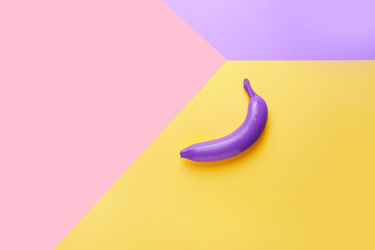 Ripe painted banana on color background