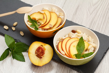 Sorghum salad with nuts and fresh peach on stone board.