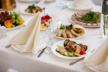 Tables setting at a luxury wedding. Table for guests. Dishes and drinks. Floral decorating, white chairs and table. Wedding table preparation. top view. horizontal photo