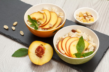 Sorghum salad with nuts and fresh peach on stone board.