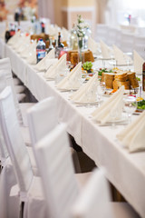 Tables setting at a luxury wedding. Table for guests. Dishes and drinks. Floral decorating, white chairs and table. Wedding table preparation. top view. vertical photo
