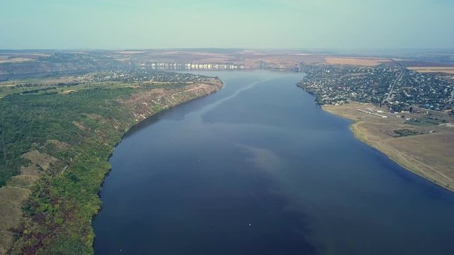 Top view of Dnestr Dniester river in autumn. River surrounds yellow field and green forest. Moldova republic of.