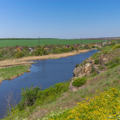 Fototapeta na wymiar Spring landscape with rocky Sura riverside and summer cottages near Dnipro city, Ukraine