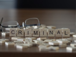 The concept of Criminal represented by wooden letter tiles