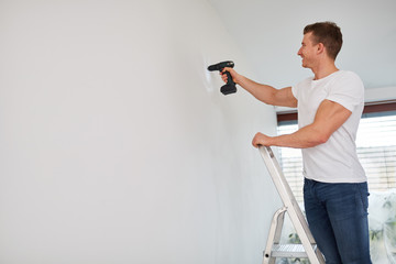 Mann arbeitet mit einer Bohrmaschine