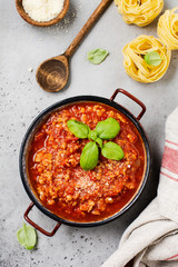 Traditional italian Bolognese sauce in saucepot an old dark wooden background. Top view, copy space