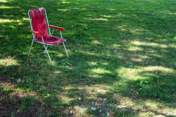 Obraz na płótnie Canvas un fauteuil rouge sur du gazon