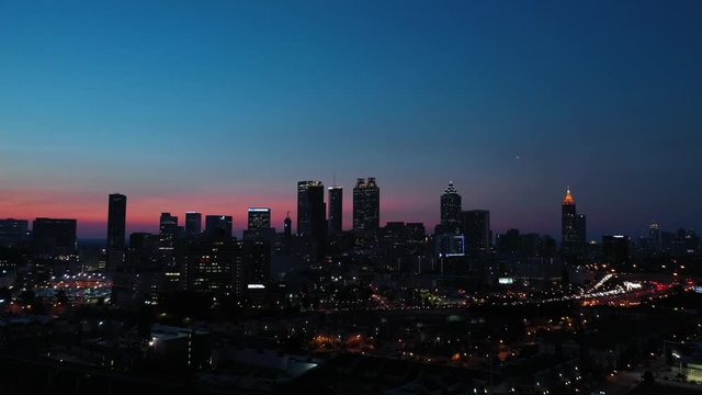 4K Ariel Drone Shot Over Charlotte At Sunset, North Carolina, USA. Beautiful Pink And Blue Sky. Skyline Line Lit Up Buildings At Night Time.