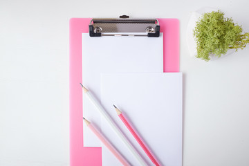 Pink clipboard, paper and group of pencils.