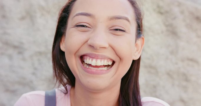 A young dark-haired lady smiling outdoors