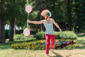 Mime performs in the park with balloons. Clown shows pantomime on the street.