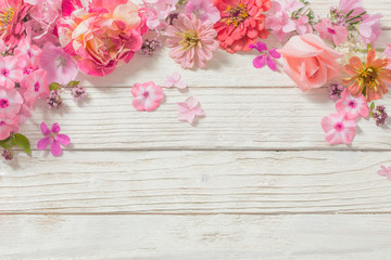 Obraz na płótnie Canvas pink flowers on white wooden background