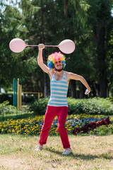 Mime performs in the park with balloons. Clown shows pantomime on the street.