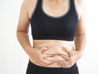 cellulite and belly fat in woman, She grabbing her abdomen near waist cause of fatty from weight...