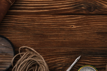 top view on twine near magnifying glass, nib and compass on wooden surface with copy space