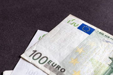 View of several hundred euro banknotes in different arrangements against black background