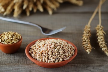 Bowls with wheat grains on light background.
Top view. Ears of wheat. Rustic style.