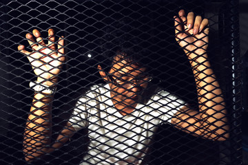 a man behind a metal fence. crime and domestic violence.