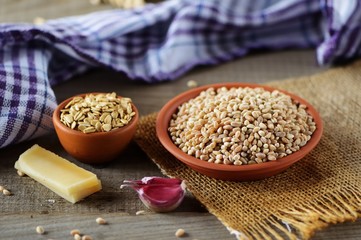 Wheat grain in dishes on the table.grains and wheat ears on a wooden table, top view