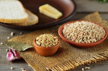 Wheat grain in dishes on the table.grains and wheat ears on a wooden table, top view