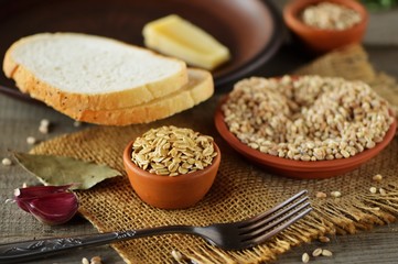 Wheat grain in dishes on the table.grains and wheat ears on a wooden table, top view