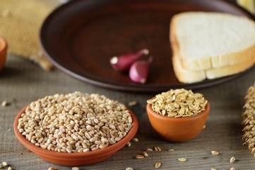 Wheat grain in dishes on the table.grains and wheat ears on a wooden table, top view