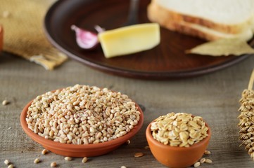 Wheat grain in dishes on the table.grains and wheat ears on a wooden table, top view