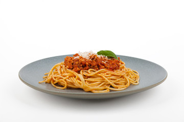 Spaghetti bolognese on a gray plate. Packshot.