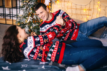 couple in love having fun on bed near Christmas tree. smile.