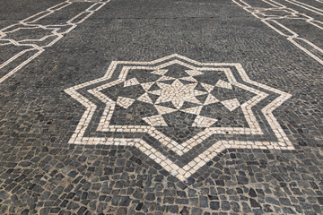 Fototapeta premium Cobbled textured background with eight pointed star mosaic ornament